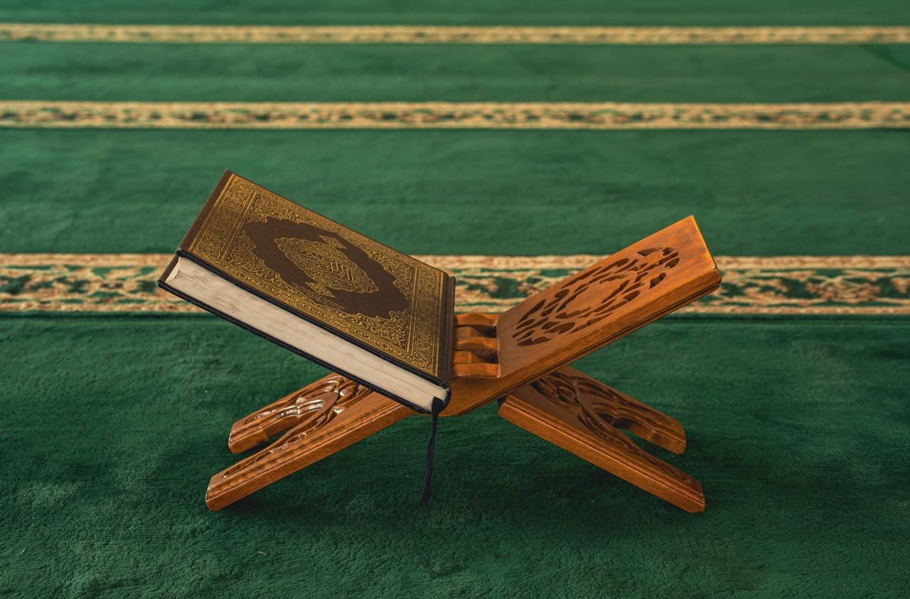 Qur'an on a wooden stand in a mosque, symbolizing Islamic faith and spirituality.