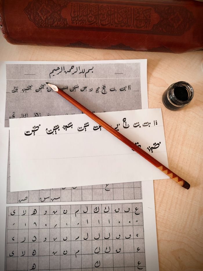 Explore traditional calligraphy with ink and brush in this artistic setup, showcasing elegant handwritten script.