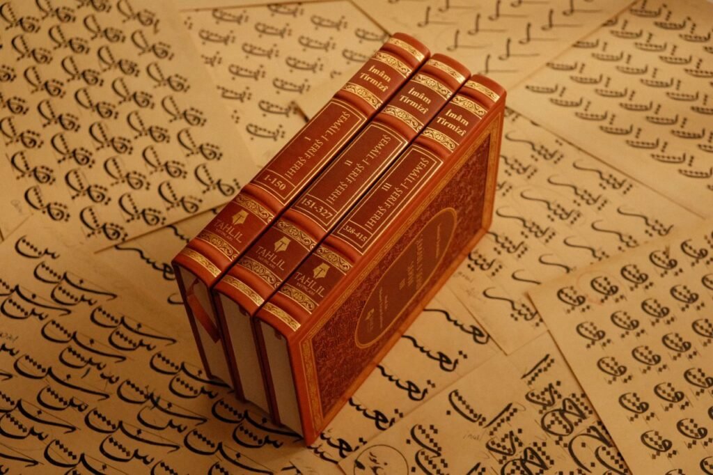 A stack of vintage books titled 'Imam-i Tirmizi' placed on traditional script pages.